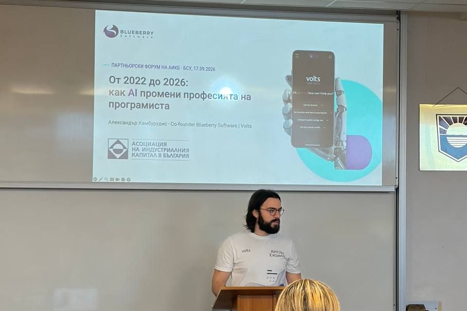 Alexander speaking at a podium under his slide, “From 2022 to 2026: how AI changed the programmer’s profession”